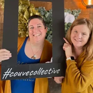Two women holding a picture frame with the hashtag # couvecollective.