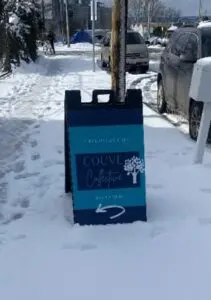 A sign in the snow that says " louve la fontaine ".
